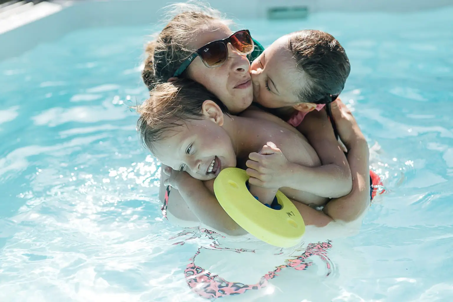 Mama mit zwei Kindern im Pool